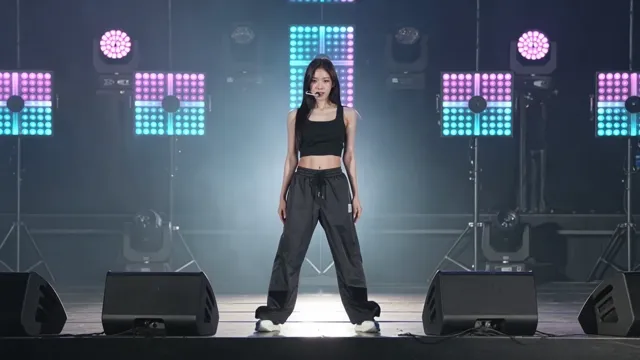 Kling 3 — Medium shot of a K-pop style dancer on a dark stage with LED panels behind her pulsing in sync. 